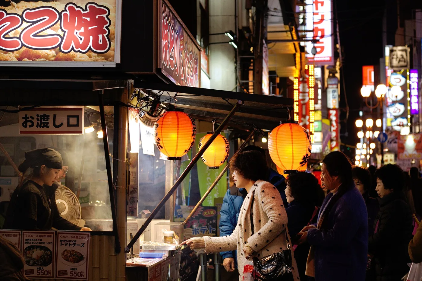 Stand de takoyaki dans une rue animée de Dōtonbori